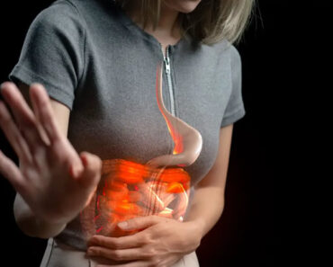 Una mujer se toca el abdomen con gesto de dolor por la acidez de estómago
